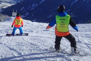 Snowboarden, begeleider volgt deelnemer