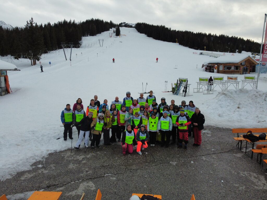 Groepsfoto Jongerenreis 2022 op het terras van het restaurant bij de Gerlos Platte met een piste op de achtergrond