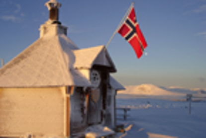 Een schuilhut naast de loipe met de Noorse vlag (rood met een blauw kruis)